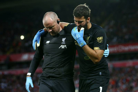 Alisson Becker injured and helped off the field.